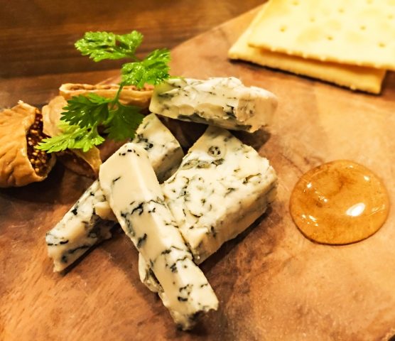 立川駅1分、本格パスタが美味しいイタリアン＆スパニッシュのお店『CANTINA 立川店』でいただける、青カビの生えたチーズ〈ブルーチーズ〉とクラッカーが木製プレートの上に盛り付けられた画像